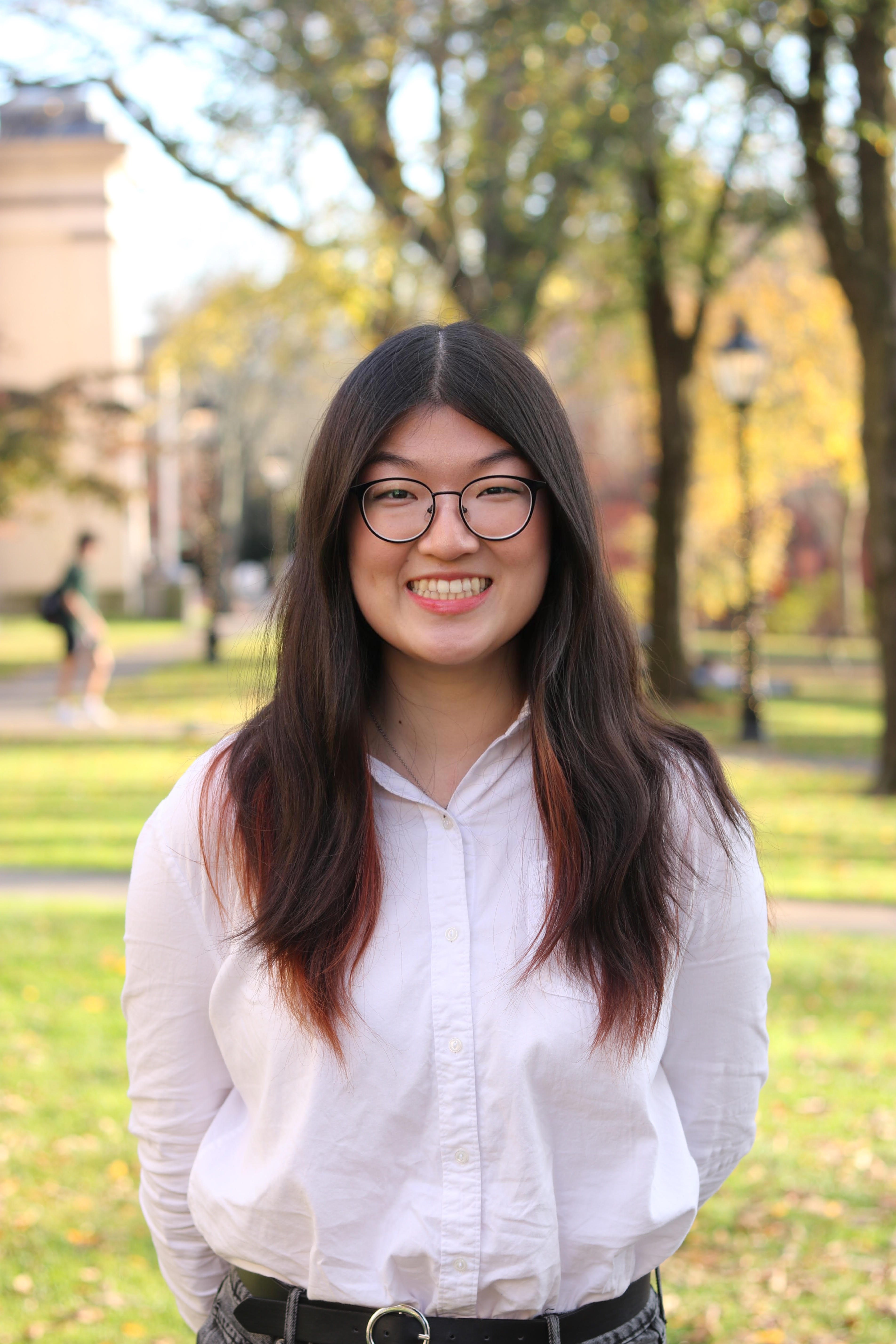 Headshot of Kathy Li wearing a white shirt on Brown University's Quiet Green